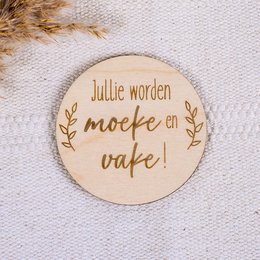 Wooden plaque with text "Jullie worden moeke en vake!" (You are becoming a mother and father!). The plaque features a simple, rustic design with a natural wood background and brown text. It is suitable for a baby-related product or gift.