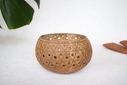 A round, natural-colored ceramic candle holder with a textured, geometric pattern. Suitable for tea lights or small candles.