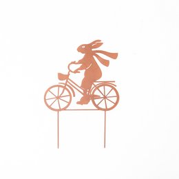 Whimsical garden sculpture of a rabbit riding a bicycle. Crafted from metal in a warm copper tone, this decorative piece adds a playful touch to any outdoor space.