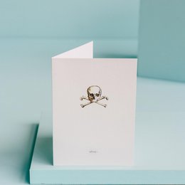 A white greeting card with a simple black and white skull and crossbones design, suitable for a friendship or casual occasion.