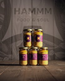 Artisanal chickpea cream spread, golden yellow creamy texture, purple label, glass jar, Italian specialty, ready-to-eat