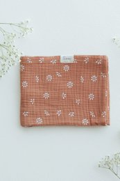 Soft, cozy baby blanket in a warm caramel color with delicate daisy floral pattern.