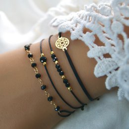A set of bracelets featuring onyx stones and a gold-colored charm. The bracelets have a sleek, minimalist design and are suitable for everyday wear.