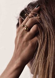 A large, bold gold ring with two spherical elements. The ring has a unique, statement-making design that would make a bold fashion accessory.