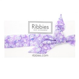 Bow headband in purple floral Liberty print. Soft, stretchy fabric for comfortable wear. Suitable for kids' hair accessories.