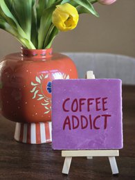 Cream-colored candles in a white box with the text "COFFEE ADDICT" printed in orange.