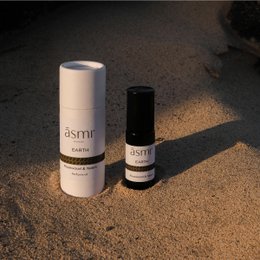  Earthy, natural perfume oil in a cylindrical glass bottle and cardboard packaging. Earthy, natural scent.