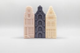 Handcrafted soap bars in a gift box, featuring coconut, cedarwood, and vetiver scents. The bars are shaped like traditional Dutch houses in neutral tones.