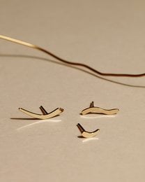 Three gold-colored stud earrings with a wave-like design.