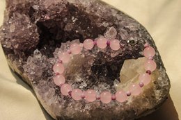  A rose quartz beaded bracelet with a circular design, featuring pink and white beads.