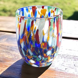 Schnapsgläser in der Hand und handgefertigtes Glas mit Murrine di Murano, "I Colori di Murano" Linie 50 ml. In Italien gemacht
