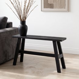 Large black wooden bench with a simple, minimalist design. Suitable for use as a bus stop or entryway seating.