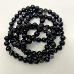 Black agate lithotherapy bracelet, available in sizes 13 cm to 18 cm. Features round, smooth black agate beads.