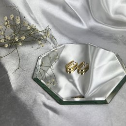Gold hoop earrings with a rectangular shape. The earrings feature a simple, minimalist design that complements a variety of fashion styles.