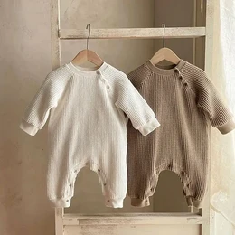 Cozy and comfortable baby rompers in neutral colors. Made of soft, breathable waffle piqué fabric. Available in sizes 3-6M, 6-12M, 12-18M, and 18-24M. Ideal for everyday wear or special occasions.
