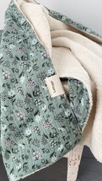 Soft, plush green baby blanket with floral pattern. Made of organic materials for gentle comfort.