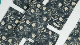 Dark teal cotton napkins with botanical forest pattern and cream accents; turquoise circular geometric print napkins.