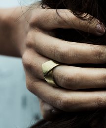 Geometric gold-tone statement ring with angular design.
