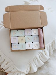 Colorful wooden alphabet blocks in a box, educational learning toy for children.