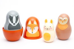 Woodland-themed nesting baby toys with chiming sounds. Includes a bunny, fox, and owl figurines in orange, brown, and gray colors. Suitable for young children's play and development.