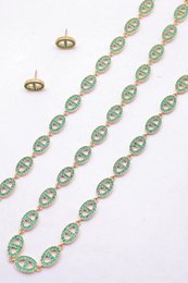 Ensemble assorti comprenant un collier, un bracelet en chaîne et une paire de boucles d'oreilles puces. Chaque bijou est composé d'une succession de maillons en forme de maille marine entièrement pavés de petits strass scintillants.