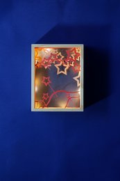 Colorful star-shaped night light with a wooden frame, designed for kids' rooms.