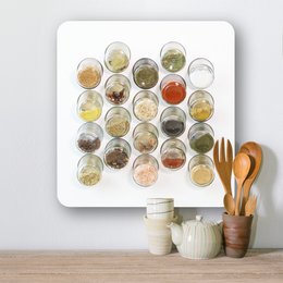 A white spice rack with 20 glass jars filled with various spices and seasonings. The rack is made of birch plywood with a white HPL front.