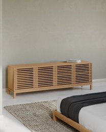 Ash wood media console with four doors and slatted design in a flaxen finish, suitable for TV storage and display.