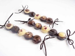  Assorted chocolate bonbons, handcrafted from bean to bar, featuring a variety of shapes and textures.