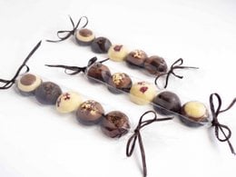 Assorted chocolate bonbons, handcrafted from bean to bar, featuring a variety of shapes and textures.