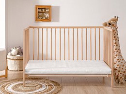 Soft, comfortable baby mattress in neutral colors with wooden frame, suitable for infants and toddlers.