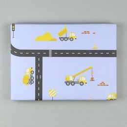 Wrapping paper featuring a construction site theme with yellow construction vehicles and road elements on a light blue background.