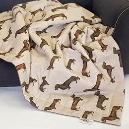 Soft, cozy dog blanket with a dachshund print pattern. Available in small (90x65cm) and medium (110x90cm) sizes. Made of high-quality, durable material for pet comfort.
