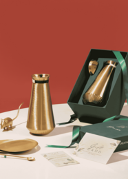 "Brass jug with yin and yang design, tall conical shape, gold metallic finish, modern minimalist style"