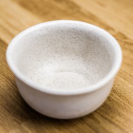 Rustic ceramic bowl with a rusty, earthy tone and a simple, minimalist design. Suitable for serving food or as a decorative piece.