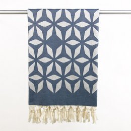 Organic cotton hammam towel in a steel blue color with a geometric floral pattern and tasseled edges, suitable for use in the bathroom or as a decorative accent.