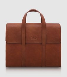 Cognac-colored leather briefcase with two compartments and a top handle for carrying laptops and other office essentials.