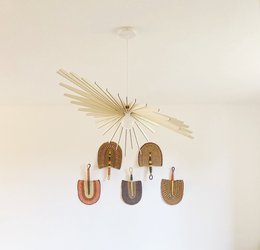Elegant pendant lighting fixture with a minimalist, modern design featuring a circular arrangement of wooden pendants suspended from a central brass sunburst-style frame.
