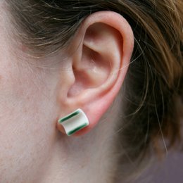 Porcelain ear studs in blue, green, ochre, and pink colors with a half-tube shape.