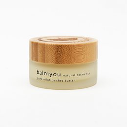 Unrefined, cold-pressed, organic, vegan shea butter cream in a 30ml jar with a bamboo lid.