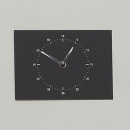 Black clock-shaped card with minimalist design.