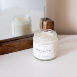 Pomegranate and pear scented candle, available in 120ml and 250ml sizes. Features a round, tall shape with a vibrant red color.