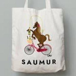 White tote bag with a brown horse riding a bicycle and the text "SAUMUR" printed on it.