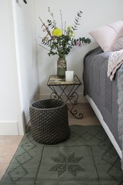 Olive green woven cotton rug with geometric pattern, medium size, suitable for use as an area rug.