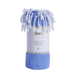 Blue and white diamond patterned hammam towel with tasseled edges.