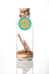 Spiced rum bottle with "Pepper Chilli" label, containing cinnamon sticks and other spices.