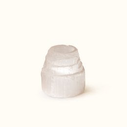 A tall, cylindrical selenite tower tea light candle holder with a soft, natural glow.