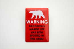 Rectangular enamel sign with warning about dangerous marine life in Svalbard area. Available in red, navy blue, and white color variants.