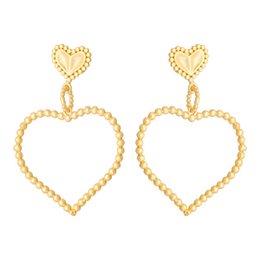 "Double Heart Statement Earrings in gold tone with heart-shaped design and beaded detailing."
The image shows a pair of statement earrings with a heart-shaped design. The earrings are made of gold-toned metal and feature a beaded texture, creating a decorative and eye-catching look. The heart shape at the top of the earrings is a key design element, making these earrings a bold and stylish accessory.