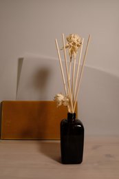 Aroma diffuser with lavender, herb, fig, pomegranate, and orange scents in a black glass bottle with dried flower accents.